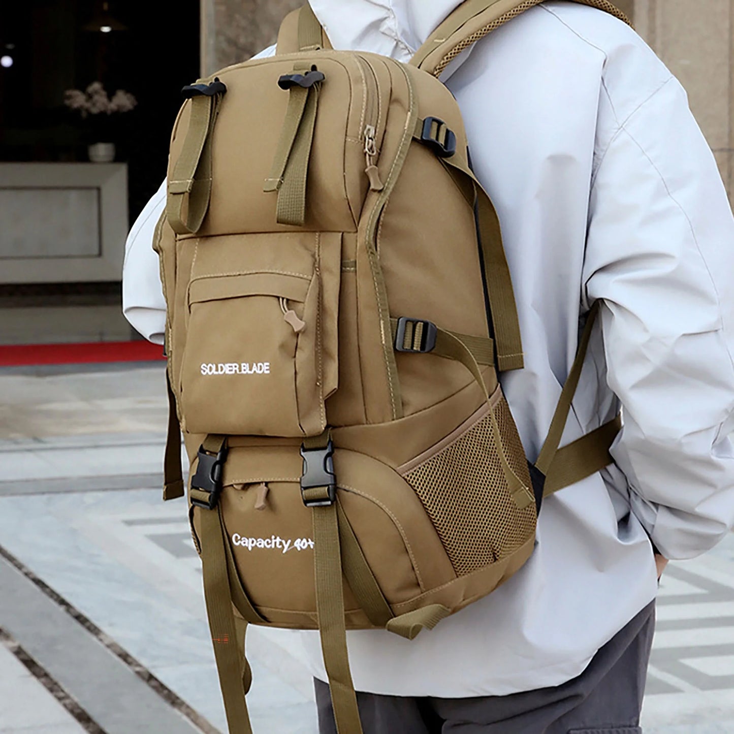 "45L Waterproof Backpack - durable climbing daypack for men and women in khaki with built-in emergency whistle and external straps."